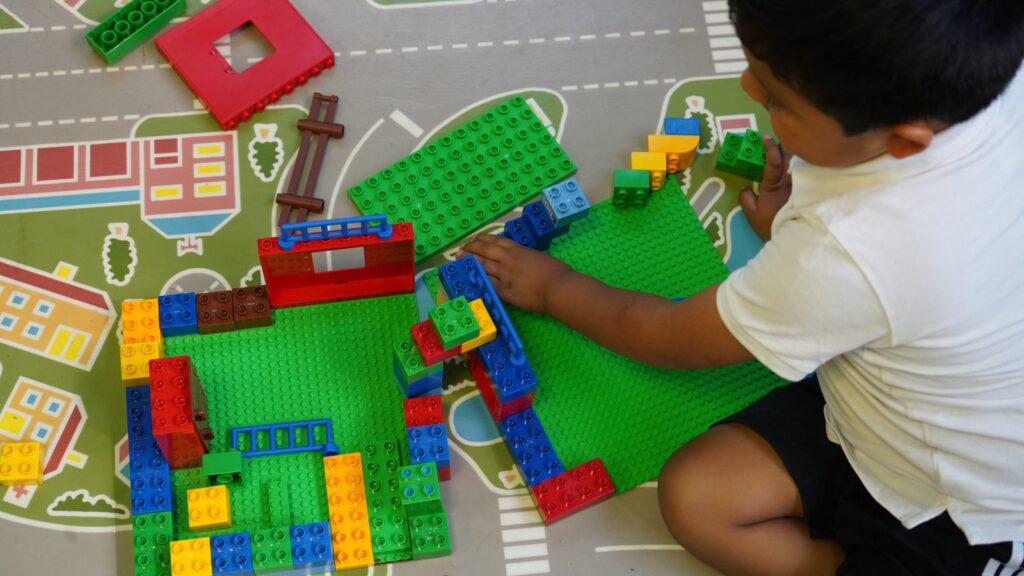 Niño construyendo con piezas de colores en el espacio educativo de Amoverse